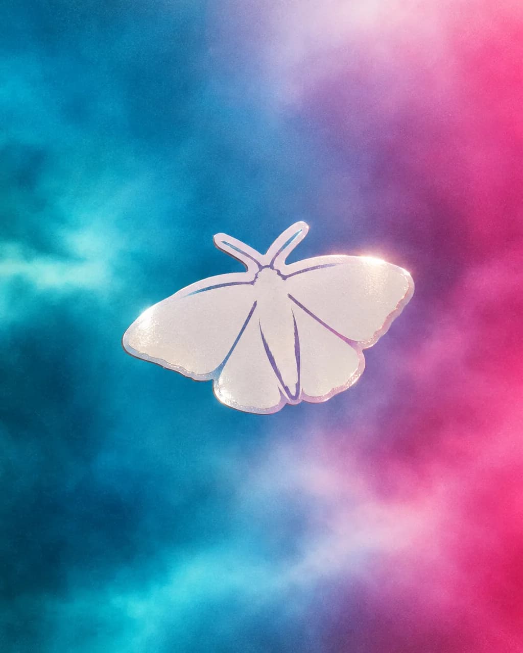 White moth vinyl sticker hovering on a cyan and magenta wash