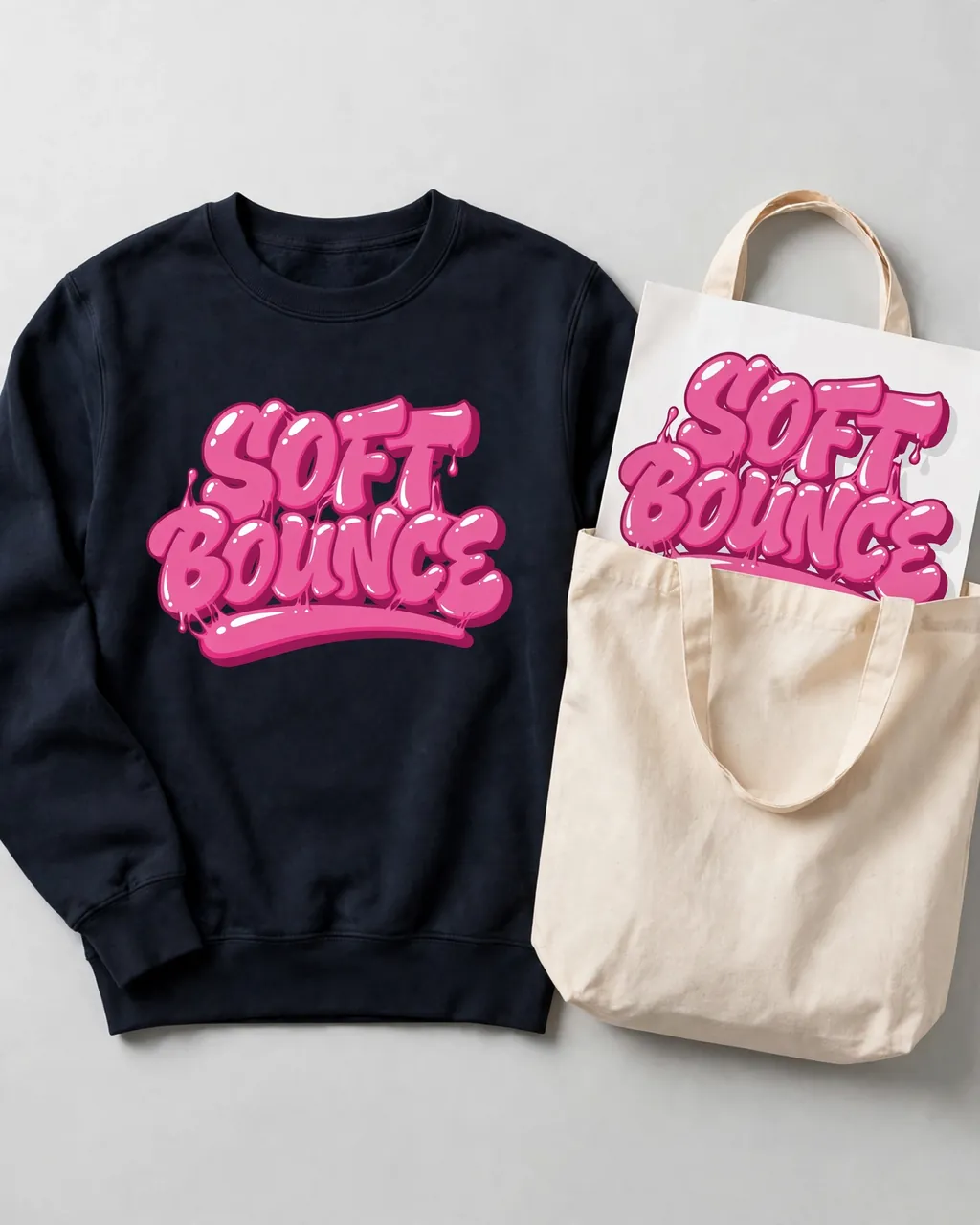 Dark sweatshirt and canvas tote carrying the same script graphic